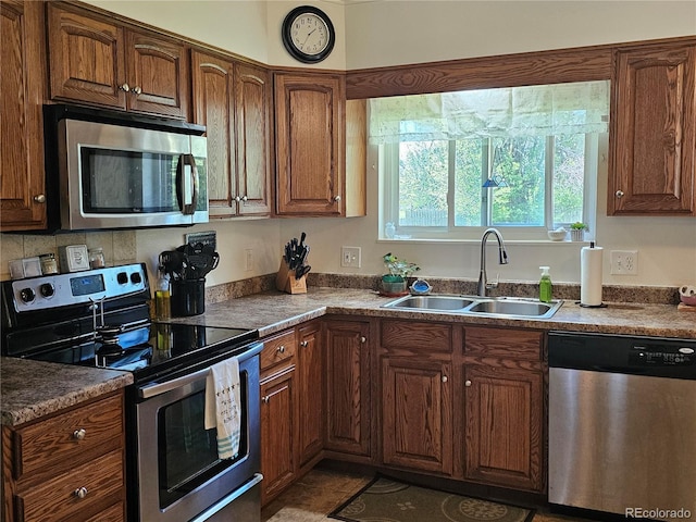kitchen featuring a sink, stainless steel appliances, and brown cabinets