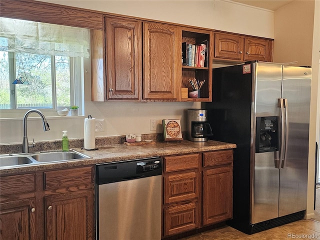 kitchen featuring brown cabinetry, open shelves, appliances with stainless steel finishes, and a sink