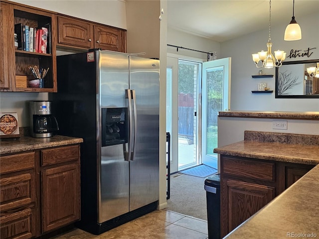 kitchen with light tile patterned floors, open shelves, stainless steel refrigerator with ice dispenser, light colored carpet, and a chandelier