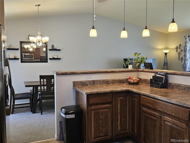 kitchen featuring carpet flooring, dark brown cabinets, dark countertops, and a chandelier