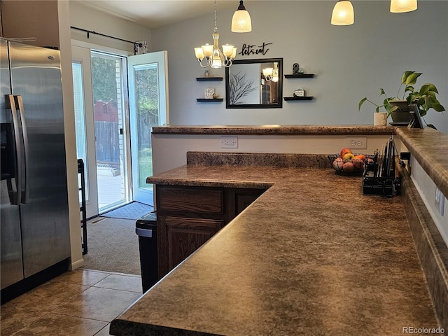 kitchen with an inviting chandelier, tile patterned floors, dark countertops, and stainless steel fridge with ice dispenser