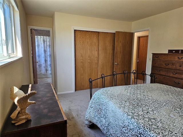 bedroom featuring baseboards, a closet, and carpet