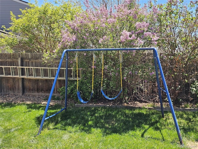 view of playground with fence and a lawn