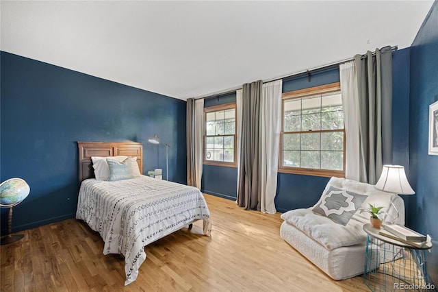 7563 Lamar Ct, Arvada, CO 80003 - bedroom featuring multiple windows, wood finished floors, and an accent wall