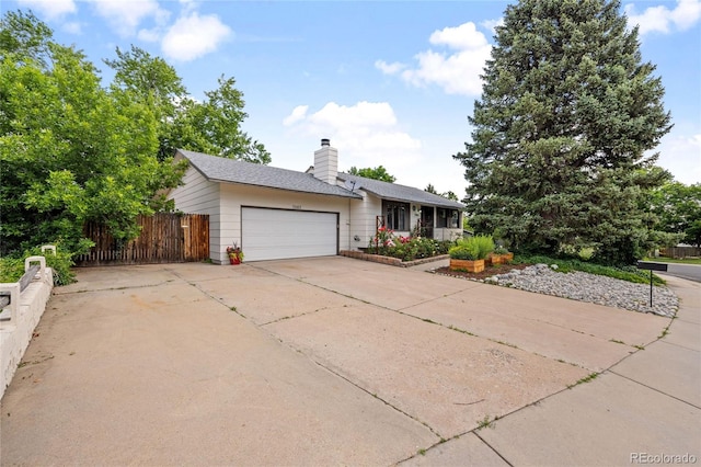 7563 Lamar Ct, Arvada, CO 80003 - view of front of property with a garage, concrete driveway, and a chimney