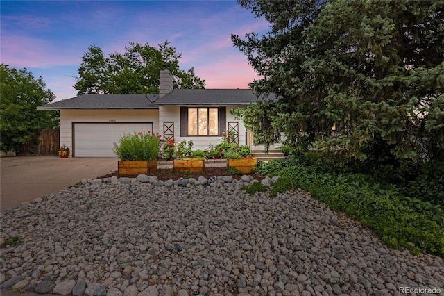 7563 Lamar Ct, Arvada, CO 80003 - view of front of home featuring driveway, an attached garage, and a chimney