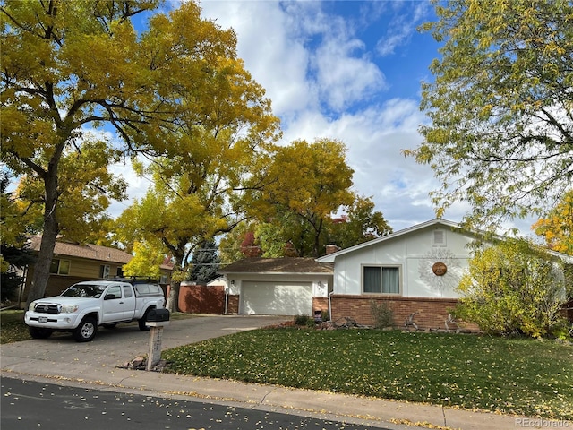 single story home with fence, concrete driveway, a front yard, a garage, and brick siding