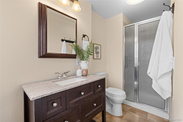 bathroom featuring tile patterned floors, a stall shower, toilet, and vanity