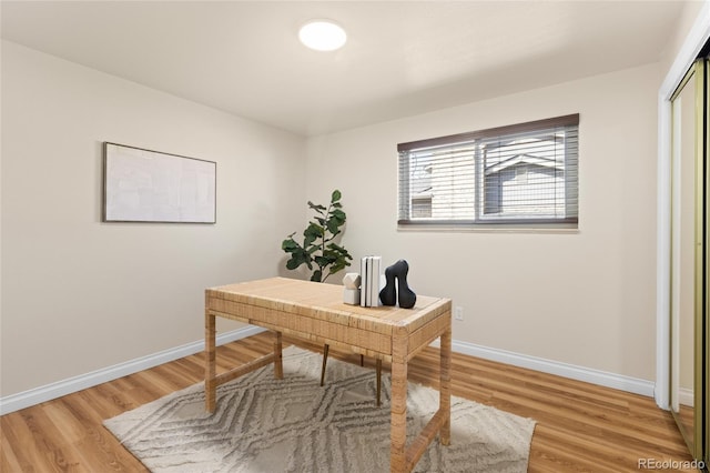 home office with light wood-type flooring and baseboards