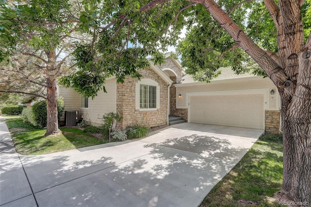 7400 W Grant Ranch Blvd Unit 9, Littleton, CO 80123 - obstructed view of property with stone siding, driveway, and a garage