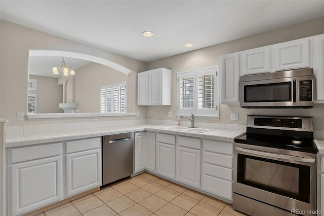7400 W Grant Ranch Blvd Unit 9, Littleton, CO 80123 - kitchen featuring appliances with stainless steel finishes, healthy amount of natural light, white cabinetry, recessed lighting, and light tile patterned flooring