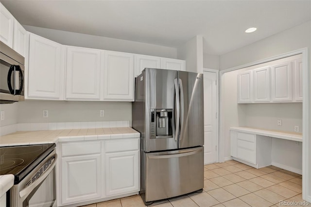 7400 W Grant Ranch Blvd Unit 9, Littleton, CO 80123 - kitchen featuring appliances with stainless steel finishes, white cabinets, light tile patterned floors, tile counters, and recessed lighting