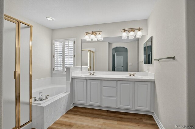 7400 W Grant Ranch Blvd Unit 9, Littleton, CO 80123 - bathroom featuring a shower stall, double vanity, a garden tub, and wood finished floors