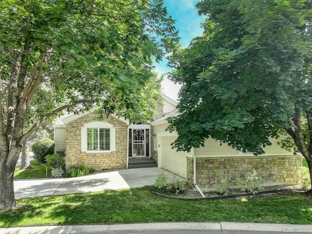 7400 W Grant Ranch Blvd Unit 9, Littleton, CO 80123 - obstructed view of property with stone siding, driveway, and an attached garage