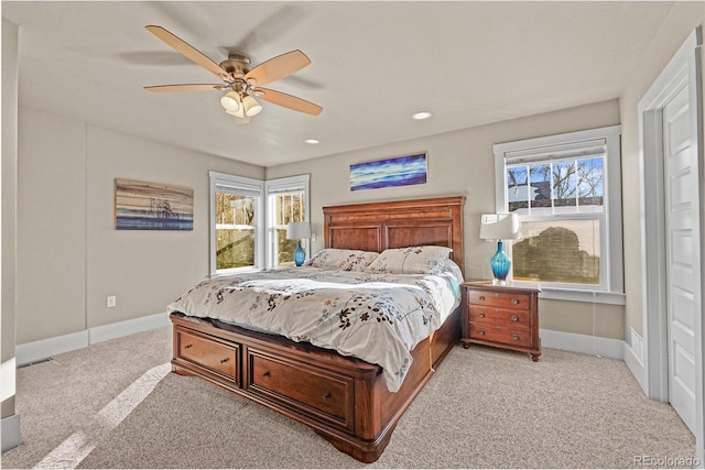 carpeted bedroom with multiple windows and ceiling fan