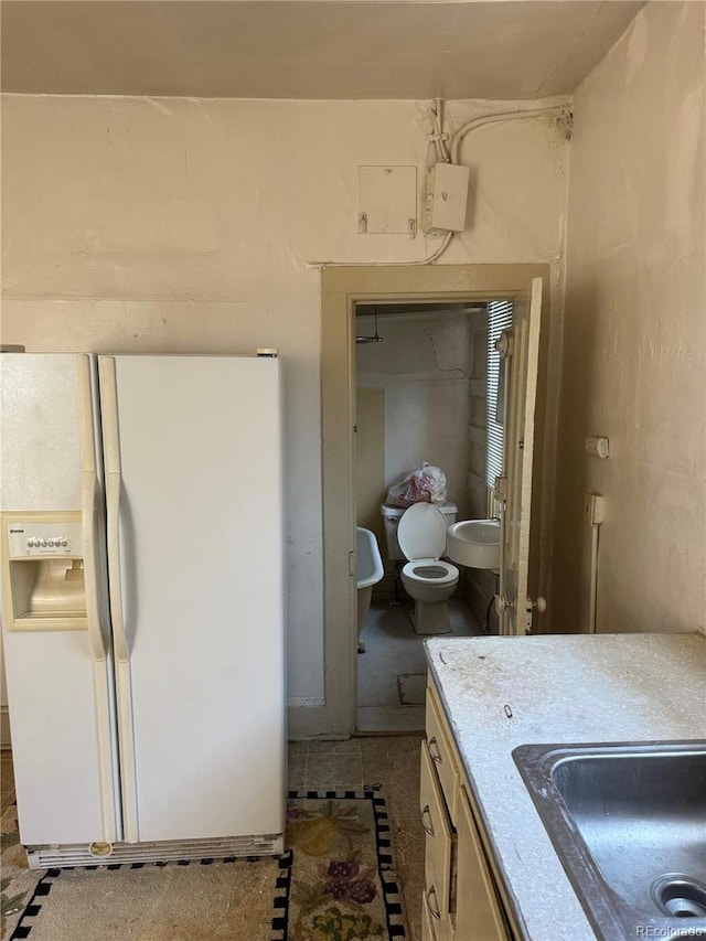 interior space featuring white refrigerator with ice dispenser and sink