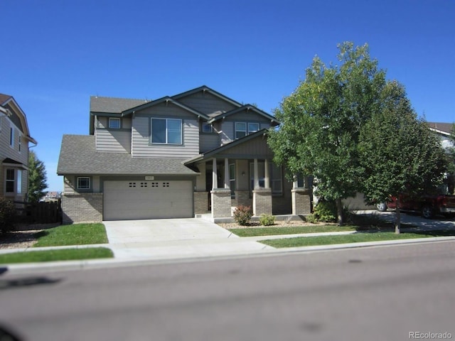 11811 Lewiston St, Commerce City, CO 80022 - craftsman-style home with brick siding, driveway, a garage, covered porch, and a shingled roof