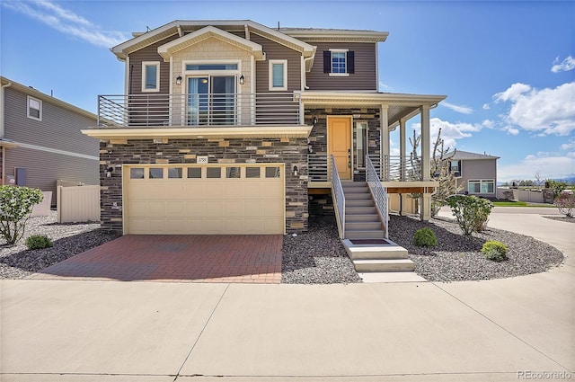 view of front facade with a balcony, a porch, and a garage