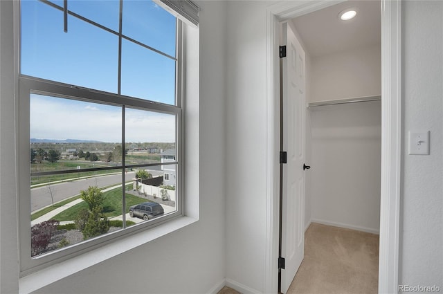 hall featuring light colored carpet