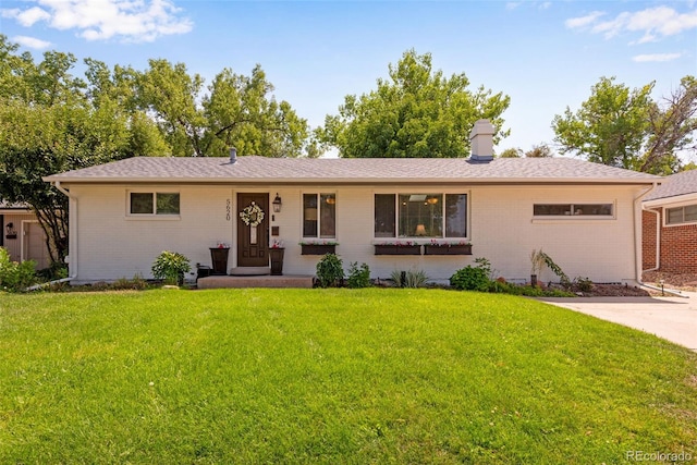 ranch-style home featuring a front lawn and brick siding