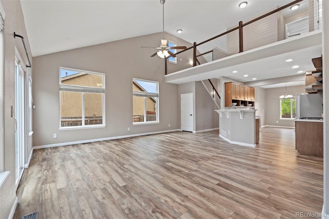 12532 Mount Belford Way, Peyton, CO 80831 - unfurnished living room featuring high vaulted ceiling, a ceiling fan, light wood finished floors, baseboards, and recessed lighting