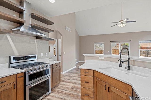 12532 Mount Belford Way, Peyton, CO 80831 - kitchen featuring range with two ovens, a sink, lofted ceiling, wall chimney range hood, and open shelves