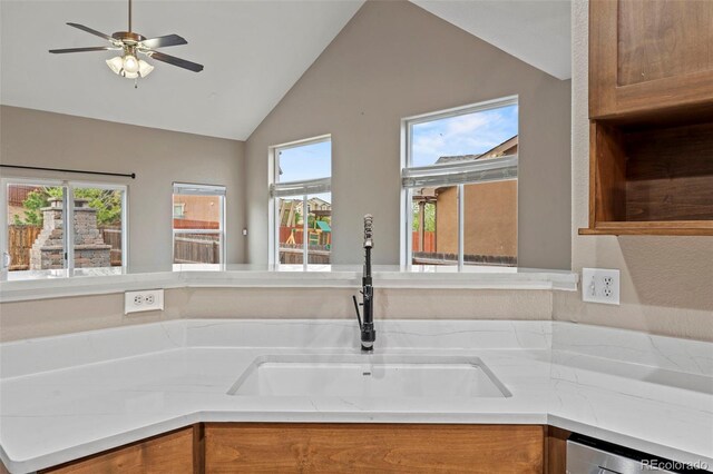 12532 Mount Belford Way, Peyton, CO 80831 - kitchen featuring a sink, vaulted ceiling, brown cabinets, ceiling fan, and healthy amount of natural light