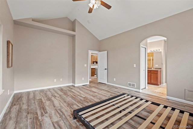 12532 Mount Belford Way, Peyton, CO 80831 - unfurnished bedroom featuring light wood-style floors, arched walkways, connected bathroom, and high vaulted ceiling