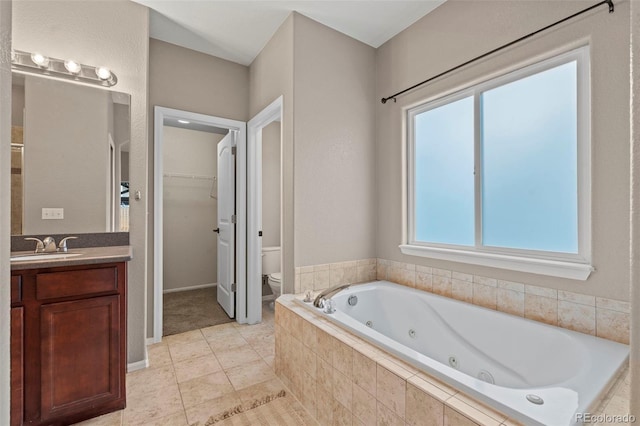 12532 Mount Belford Way, Peyton, CO 80831 - bathroom featuring toilet, a whirlpool tub, vanity, tile patterned flooring, and a walk in closet
