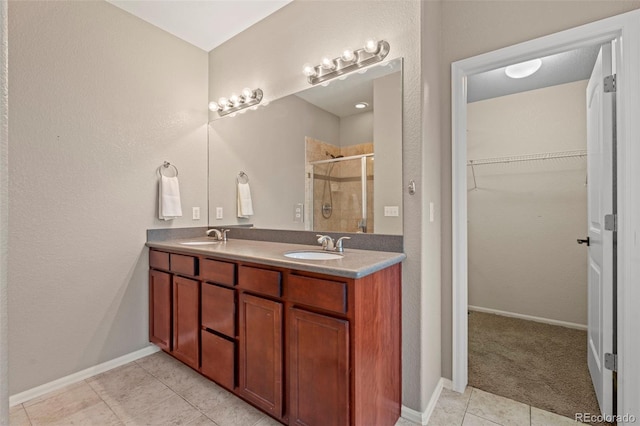 12532 Mount Belford Way, Peyton, CO 80831 - full bathroom with a stall shower, double vanity, a walk in closet, tile patterned flooring, and baseboards