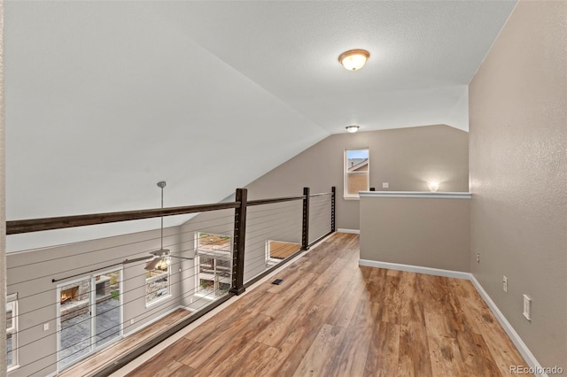 12532 Mount Belford Way, Peyton, CO 80831 - corridor featuring wood finished floors, vaulted ceiling, baseboards, and an upstairs landing