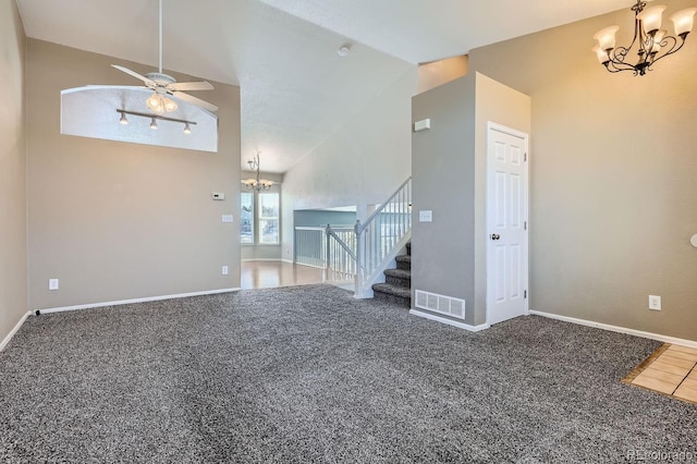 unfurnished living room featuring vaulted ceiling, carpet floors, and ceiling fan with notable chandelier