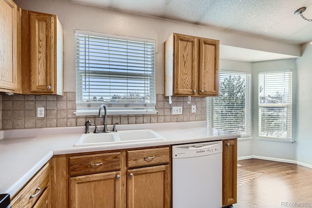 kitchen featuring plenty of natural light, dishwasher, sink, and decorative backsplash