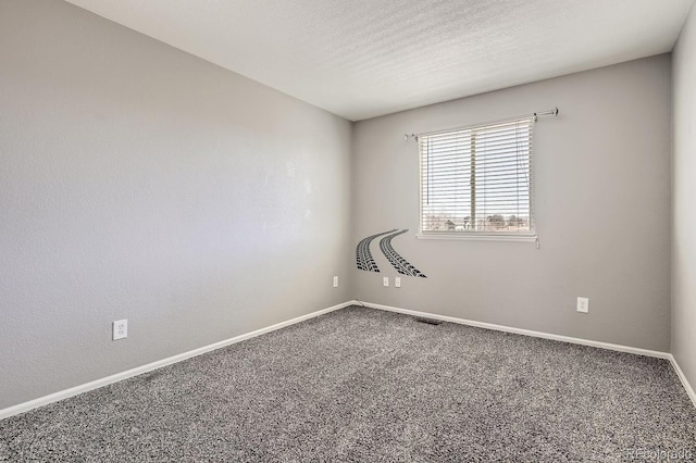 spare room with a textured ceiling and carpet