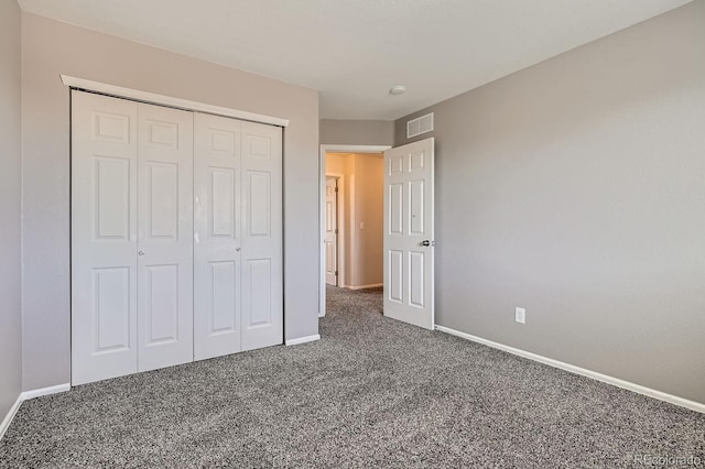 unfurnished bedroom with dark carpet and a closet