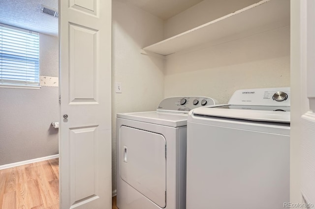 laundry room featuring washer and dryer and light wood-type flooring