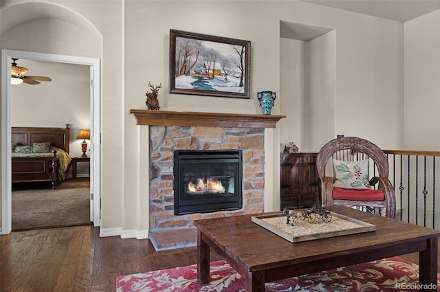 15616 Soo Line Way, Monument, CO 80132 - living area featuring hardwood / wood-style floors, baseboards, ceiling fan, and a stone fireplace