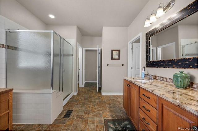 15616 Soo Line Way, Monument, CO 80132 - full bathroom with stone finish floors, vanity, a stall shower, baseboards, and recessed lighting