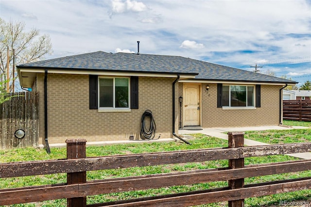 710 4th St, Bennett, CO 80102 - view of front of home featuring fence, brick siding, and a shingled roof