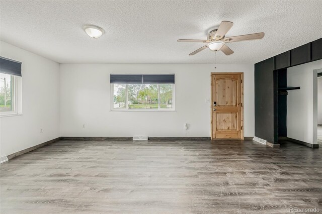 710 4th St, Bennett, CO 80102 - unfurnished room with wood finished floors, plenty of natural light, a textured ceiling, a ceiling fan, and baseboards