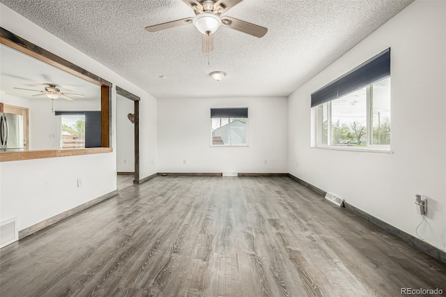 710 4th St, Bennett, CO 80102 - spare room with ceiling fan, a textured ceiling, wood finished floors, and healthy amount of natural light