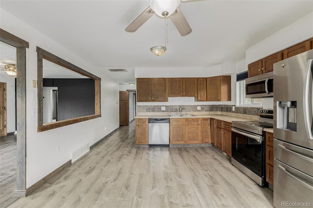 710 4th St, Bennett, CO 80102 - kitchen with appliances with stainless steel finishes, ceiling fan, a sink, light countertops, and light wood-style flooring