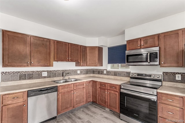 710 4th St, Bennett, CO 80102 - kitchen with stainless steel appliances, a sink, light wood finished floors, and light countertops