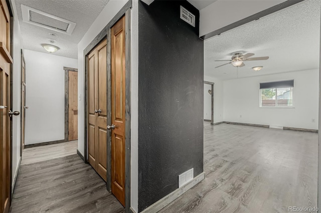 710 4th St, Bennett, CO 80102 - hallway featuring a textured ceiling, wood finished floors, and baseboards