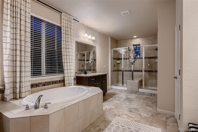 bathroom with vanity, a textured ceiling, and plus walk in shower