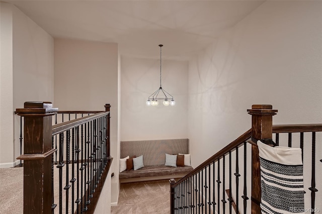 stairway featuring carpet flooring and a chandelier