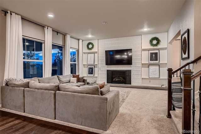 living room with a fireplace and dark wood-type flooring