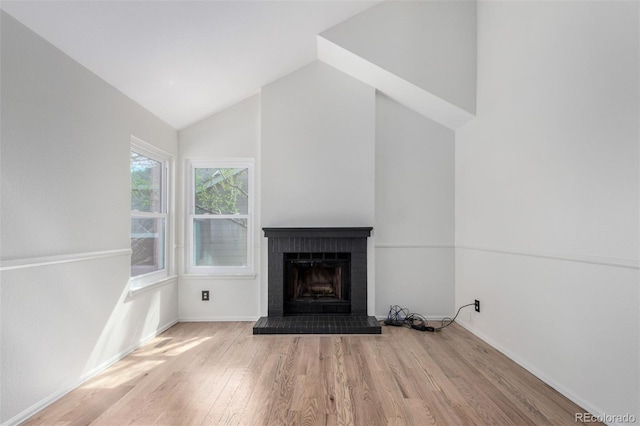 772 Ivywood Ct, Highlands Ranch, CO 80126 - unfurnished living room with wood finished floors, a brick fireplace, baseboards, and high vaulted ceiling