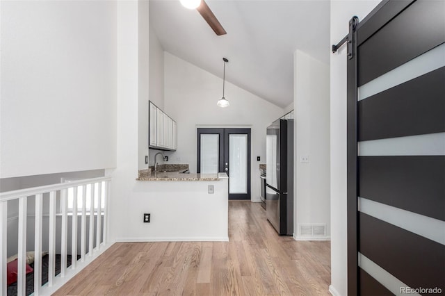 772 Ivywood Ct, Highlands Ranch, CO 80126 - corridor with high vaulted ceiling, light wood finished floors, a sink, a barn door, and baseboards