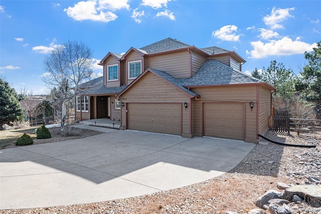 view of front of property with concrete driveway, fence, a garage, and a shingled roof